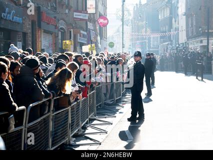 London, England, Großbritannien. Menschenmassen und Polizei in Brick Lane warten auf die Ankunft von König Charles und Camilla für einen Besuch der Moschee. 8. Februar 2023 Stockfoto