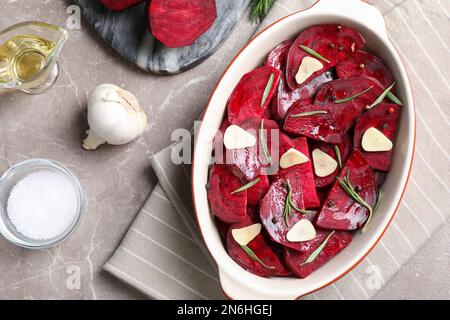 Flache Laienzusammensetzung mit rohen Rote-Bete-Scheiben auf dem Marmortisch Stockfoto