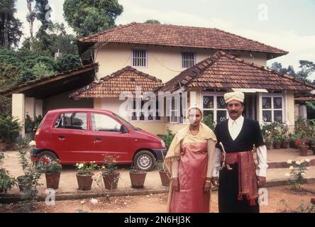 Kodava-Paar in einem traditionellen Haus vor ihrem Haus, Kodagu Coorg, Karnataka, Indien Stockfoto