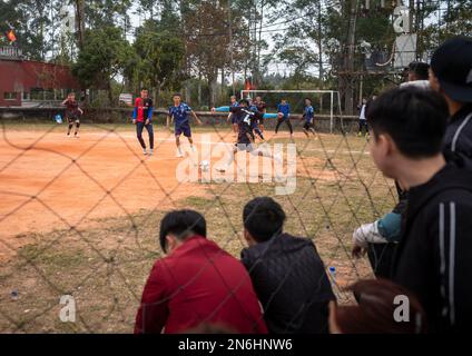 Eine Gruppe vietnamesischer Teenager schaut sich ein lokales Fußballspiel in der Nähe der chinesischen Grenze in Tra Co, in der Nähe von Mong Cai in Vietnam an. Stockfoto