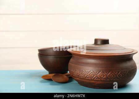 Set aus Tonschalen auf hellblauem Holztisch. Platz für Text Stockfoto