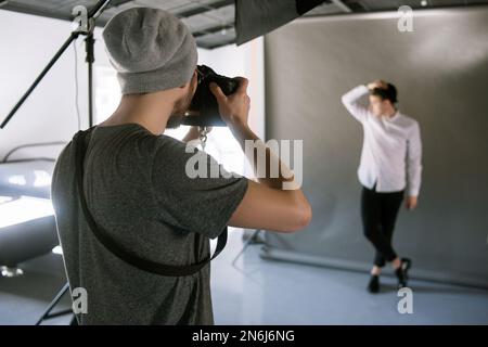 Nicht wiedererkennbarer Mann, der auf ein männliches Model schießt Stockfoto