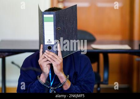 Frankenthal, Deutschland. 10. Februar 2023. Der Angeklagte sitzt in Handschellen im Gerichtssaal des Bezirksgerichts. Etwa vier Monate nach dem Messerangriff, bei dem zwei Tote und einer schwer verletzt wurden, in Ludwigshafen-Oggersheim in Rheinland-Pfalz beginnt der Prozess gegen den mutmaßlichen Täter, einen 26-jährigen Mann aus Somalia. Der Angeklagte soll am 18. Oktober 2022 einen 20-Jährigen und einen 35-Jährigen mit einem Küchenmesser auf der Straße getötet haben. Kredit: Uwe Anspach/dpa/Alamy Live News Stockfoto