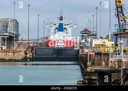 Das Flüssiggas-Tankschiff Mirasoulx wird in den Miraflores-Schleusen auf dem Panamakanal angehoben. Ein kleineres Tourboot belegt auch das Schloss. Stockfoto