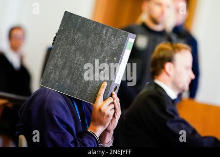 10. Februar 2023, Rheinland-Pfalz, Frankenthal: Der Beklagte (l) sitzt in Handschellen im Anhörungssaal des Landesgerichts neben seinem Anwalt Thilo Schwarz. Etwa vier Monate nach dem Messerangriff, bei dem zwei Tote und einer schwer verletzt wurden, in Ludwigshafen-Oggersheim in Rheinland-Pfalz beginnt der Prozess gegen den mutmaßlichen Täter, einen 26-jährigen Mann aus Somalia. Der Angeklagte soll am 18. Oktober 2022 einen 20-Jährigen und einen 35-Jährigen mit einem Küchenmesser auf der Straße getötet haben. Foto: Uwe Anspach/dpa Stockfoto