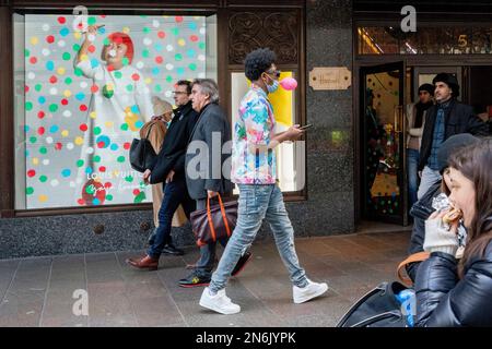 Die Öffentlichkeit interagiert am 9. Februar 2023 in London in einem Fenster von Harrods in Knightsbridge mit einer Leinwand, auf der der Künstler Yayoi Kusama zu sehen ist. Der unverkennbare Künstler Yayoi Kusama arbeitet mit Louis Vuitton zusammen, und ihre Zusammenarbeit zeigt sich derzeit in den Fenstern vieler Einzelhändler, die die französische Luxusmarke für Gepäck und Handtaschen auf Lager haben. Stockfoto