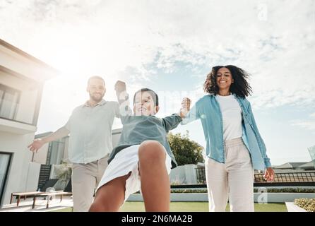 Kinder, Familie und ein Junge, der zusammen mit seinen Eltern im Garten ihres Zuhauses im Freien schwingt. Kinder, lieben oder mit Mutter, Vater und Sohn spielen Stockfoto