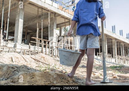 Arme Kinder, die auf der Baustelle gegen Kinderarbeit arbeiten, Kinder müssen wegen Armut arbeiten, Welttag gegen Kinderarbeit und tra Stockfoto