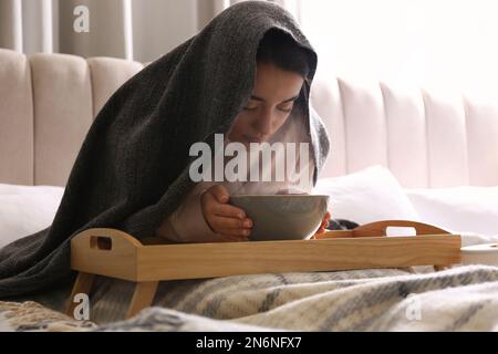 Eine Frau mit Karo, die über der Schüssel inhaliert Stockfoto