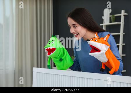 Junge Frau, die zu Hause eine Puppenshow vorführt Stockfoto