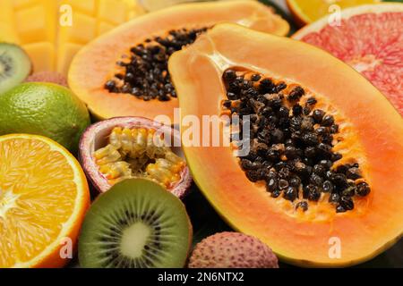 Frische reife Papaya und andere Früchte als Hintergrund, Nahaufnahme Stockfoto