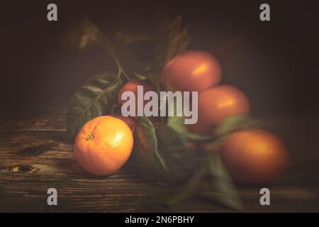 Frische Tangerinen mit Blättern auf Holzhintergrund Stockfoto
