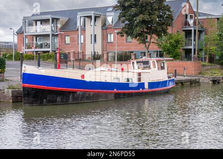 Ein kanalboot im stil eines niederländischen Kutschers, weiß-rot-blau und schwarz gestrichen, am Kennet- und Avon-Kanal am Devizes-Kai in Wiltshire vertäut Stockfoto