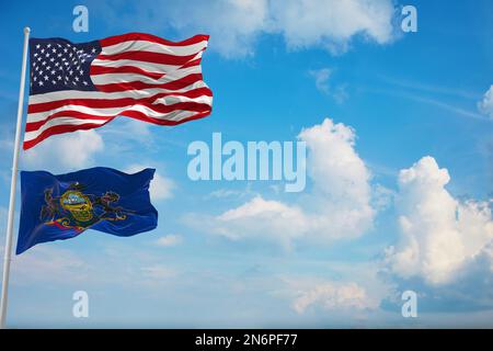 Große offizielle Flagge der USA mit kleinerer Flagge des Staates Pennsylvania, USA bei bewölktem Himmel. Patriotisches Konzept der Vereinigten Staaten von Amerika Stockfoto