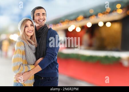 Glückliches Paar auf der Weihnachtsmesse, Platz für Text. Bokeh-Effekt Stockfoto