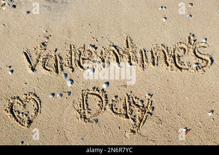 Happy Valentine's Day steht auf dem Sand des tropischen Strandes. Stockfoto