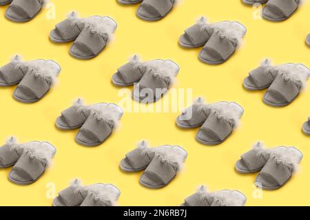 Weiche Hausschuhe auf gelbem Hintergrund mit gemustertem Design Stockfoto