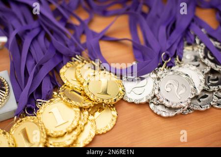 Medaillen für Sieger. Auszeichnung für sportliche Leistungen. Viele Medaillen sind auf dem Tisch. Stockfoto