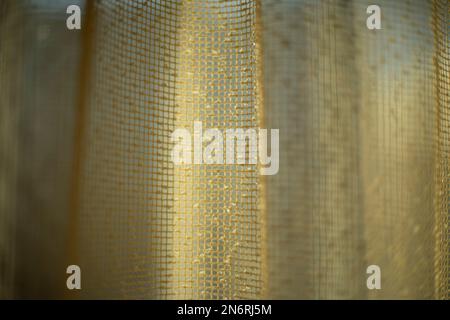 Vorhänge am Fenster. Licht durch Vorhänge. Struktur aus feinem Gitter. Falten aus Stoff. Stockfoto