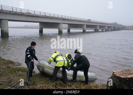 Ein Polizei Such- und Rettungsteam am Flussufer nahe der Shard Bridge am Fluss Wyre in Lancashire, während die Polizei ihre Suche nach der vermissten Frau Nicola Bulley fortsetzt, 45, Die zuletzt vor zwei Wochen am Morgen des 27. Januar gesehen wurde, als sie ihren Hund auf einem Fußweg am nahe gelegenen Fluss Wyre spazieren ging. Foto: Freitag, 10. Februar 2023. Stockfoto