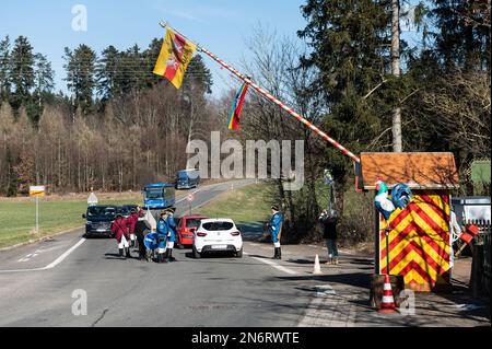 Villingen Schwenningen, Deutschland. 10. Februar 2023. Die Mitglieder der Dummheit Gockel-Gilde fordern von Autofahrern, die von Baden nach Württemberg und umgekehrt fahren, an einer Mautstelle eine „Maut“. Das eingezogene Geld wird für einen guten Zweck gespendet. In der Vergangenheit trennte eine Staatsgrenze Badeners und Württembergers. Während der Karnevalssaison wird in Villingen-Schwenningen erneut ein Zollhaus errichtet. Es gibt viel Ermutigung - aber manche kehren einfach zurück. Kredit: Silas Stein/dpa/Alamy Live News Stockfoto