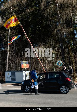 Villingen Schwenningen, Deutschland. 10. Februar 2023. Die Mitglieder der Dummheit Gockel-Gilde fordern von Autofahrern, die von Baden nach Württemberg und umgekehrt fahren, an einer Mautstelle eine „Maut“. Das eingezogene Geld wird für einen guten Zweck gespendet. In der Vergangenheit trennte eine Staatsgrenze Badeners und Württembergers. Während der Karnevalssaison wird in Villingen-Schwenningen erneut ein Zollhaus errichtet. Es gibt viel Ermutigung - aber manche kehren einfach zurück. Kredit: Silas Stein/dpa/Alamy Live News Stockfoto