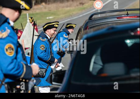 Villingen Schwenningen, Deutschland. 10. Februar 2023. Die Mitglieder des Narrenzunft Gockel-Gilde erheben für Autofahrer, die von Baden nach Württemberg und umgekehrt fahren, eine „Straßenmaut“. Das eingezogene Geld wird für einen guten Zweck gespendet. In der Vergangenheit trennte eine Staatsgrenze Badeners und Württembergers. Während der Karnevalssaison wird in Villingen-Schwenningen erneut ein Zollhaus errichtet. Es gibt viel Ermutigung - aber manche kehren einfach zurück. Kredit: Silas Stein/dpa/Alamy Live News Stockfoto