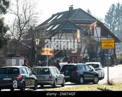 Villingen Schwenningen, Deutschland. 10. Februar 2023. Die Mitglieder der Narrenzunft Gockel-Gilde verlangen von Autofahrern, die von Baden nach Württemberg und umgekehrt fahren, Mautgebühren an einer Schnellstraße im Zollhaus-Bezirk. Das eingezogene Geld wird für einen guten Zweck gespendet. In der Vergangenheit trennte eine Staatsgrenze Badeners und Württembergers. Während der Karnevalssaison wird in Villingen-Schwenningen erneut ein Zollhaus errichtet. Es gibt viel Ermutigung - aber manche kehren einfach zurück. Kredit: Silas Stein/dpa/Alamy Live News Stockfoto