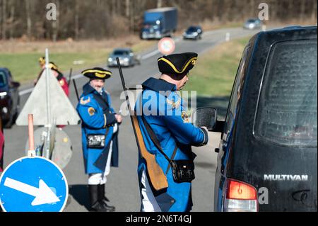 Villingen Schwenningen, Deutschland. 10. Februar 2023. Die Mitglieder des Narrenzunft Gockel-Gilde erheben für Autofahrer, die von Baden nach Württemberg und umgekehrt fahren, eine „Straßenmaut“. Das eingezogene Geld wird für einen guten Zweck gespendet. In der Vergangenheit trennte eine Staatsgrenze Badeners und Württembergers. Während der Karnevalssaison wird in Villingen-Schwenningen erneut ein Zollhaus errichtet. Es gibt viel Ermutigung - aber manche kehren einfach zurück. Kredit: Silas Stein/dpa/Alamy Live News Stockfoto