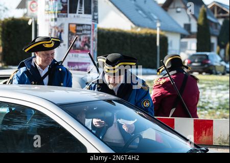 Villingen Schwenningen, Deutschland. 10. Februar 2023. Die Mitglieder des Narrenzunft Gockel-Gilde erheben für Autofahrer, die von Baden nach Württemberg und umgekehrt fahren, eine „Straßenmaut“. Das eingezogene Geld wird für einen guten Zweck gespendet. In der Vergangenheit trennte eine Staatsgrenze Badeners und Württembergers. Während der Karnevalssaison wird in Villingen-Schwenningen erneut ein Zollhaus errichtet. Es gibt viel Ermutigung - aber manche kehren einfach zurück. Kredit: Silas Stein/dpa/Alamy Live News Stockfoto