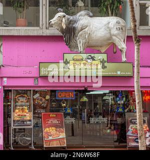 Ein großer Plastikochse markiert das Fenster eines Burger- und Fleischrestaurants in Bogota, Kolumbien Stockfoto