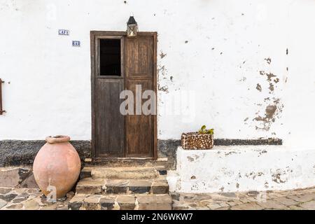 Haustür eines Hauses in Betancuria, Fuerteventura, mit Terrakotta-Glas, Blumenkasten und Laterne. Stockfoto