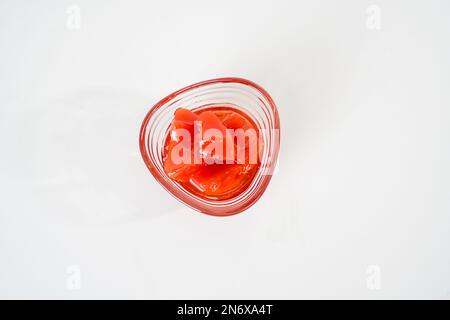 Hausgemachte Quittenmarmelade in einer kleinen Glasschüssel isoliert auf weißem Hintergrund. Stockfoto