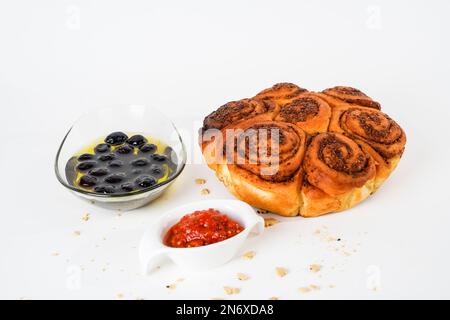 Alligatbrot mit Walnuss-Mohn-Sesam, marinierten reifen schwarzen Oliven und Chili-Tomaten-Sauce, isoliert auf weißem Hintergrund. Stockfoto