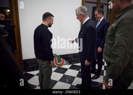 Brüssel, Belgien. 09. Februar 2023. Der ukrainische Präsident Volodymyr Zelenskyy, links, präsentiert König Philippe von Belgien in der Mitte mit einem Fragment eines russischen Su-25-Flugzeugs, das von ukrainischen Piloten am Königspalast am 9. Februar 2023 in Brüssel abgeschossen wurde. Kredit: Pool Photo/Pressestelle Des Ukrainischen Präsidenten/Alamy Live News Stockfoto