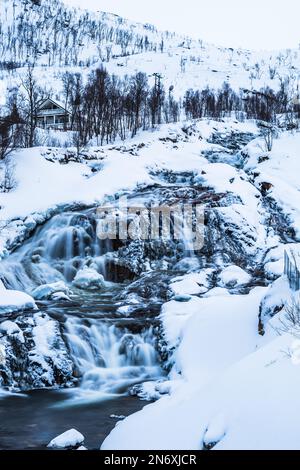 Wasserfall auf dem Fluss Ersfjordelva im Winter, Ersfjordbotn, Troms, Norwegen, vertikal, In der Nähe der Stadt Tromso Stockfoto