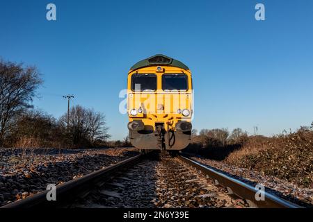 Ein kleiner Blickwinkel nach vorn eines Güterlokomotivenmotors, der sich einem Eindringling auf einer Eisenbahnlinie nähert, in einem Betriebssicherheitsbild mit Kopie Spac Stockfoto