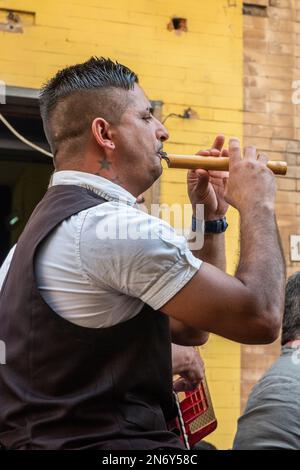 In Maletto, Sizilien, spielt ein Volksmusiker eine sizilianische Schilfflöte ( Friscalettu oder Zufolo). Diese werden traditionell aus Schilf mit einem langen, hohlen und robusten Stiel (Arundo Donax oder Riesenschildkröte) hergestellt. Stockfoto