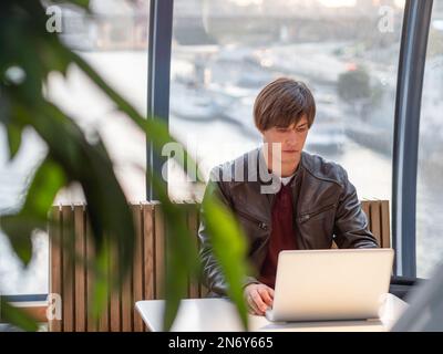 Geschäftsmann arbeitet mit Laptop- und Papierorganisator in einem Co-working Center zusammen. Arbeitsplatz für Freiberufler im Business Center. Stockfoto