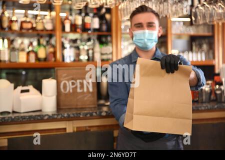 Kellner mit gepackten Speisen zum Mitnehmen im Restaurant. Gastronomie während der Coronavirus-Quarantäne Stockfoto