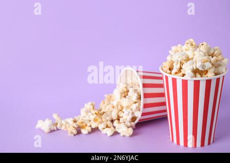 Köstliches Popcorn auf lilafarbenem Hintergrund. Platz für Text Stockfoto