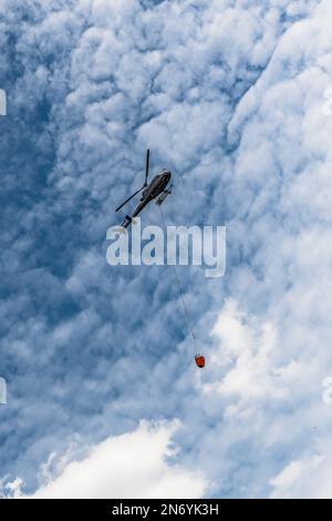 Wendefurth, Deutschland - 17.06.22: Hubschrauber mit einem Tank voller Löschwasser fliegt zu einem Waldbrand Stockfoto