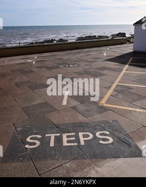 Warnschilder zu teilweise versteckten Stufen entlang der Küste von Dawlish, South Devon. Stockfoto