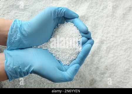 Bauer, der Ammoniumnitrat-Pellets in Händen hält, Draufsicht. Mineraldünger Stockfoto