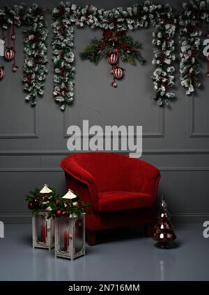 Sessel im Wohnzimmer mit Laternen und Weihnachtsdekorationen Stockfoto