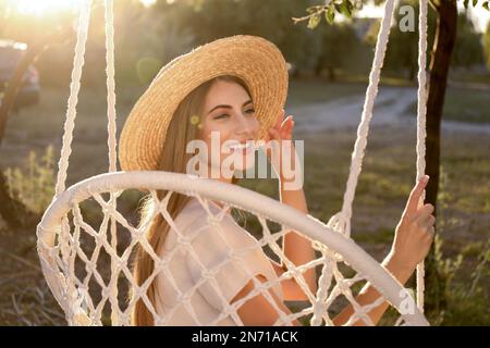 Junge Frau, die sich an sonnigen Tagen im Liegestuhl ausruht. Sommerferien Stockfoto