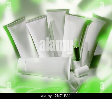 Gruppe von Eigenmarken-Kosmetikröhren im reflektierenden Konzeptstudio-Foto. Insgesamt ist diese Farbe Grün. Stockfoto