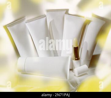 Gruppe von Eigenmarken-Kosmetikröhren im reflektierenden Konzeptstudio-Foto. Insgesamt ist diese Farbe Gelb. Stockfoto