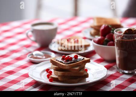 Getoastetes Brot mit Schokoladenaufstrich und Cranberries auf dem Tisch in der Küche Stockfoto