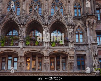 Fassade des neogotischen Rathauses mit täglichen Aufführungen zum Glockengeräusch und einem hohen Turm mit Blick auf die Stadt am Marienplatz München Stockfoto